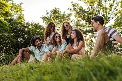 Group of young adults sat outdoors in the sun