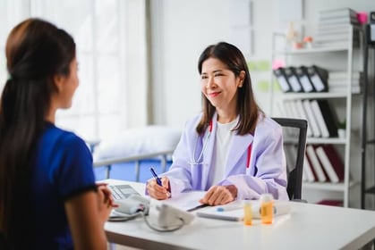 A doctor talking to a patient and taking notes