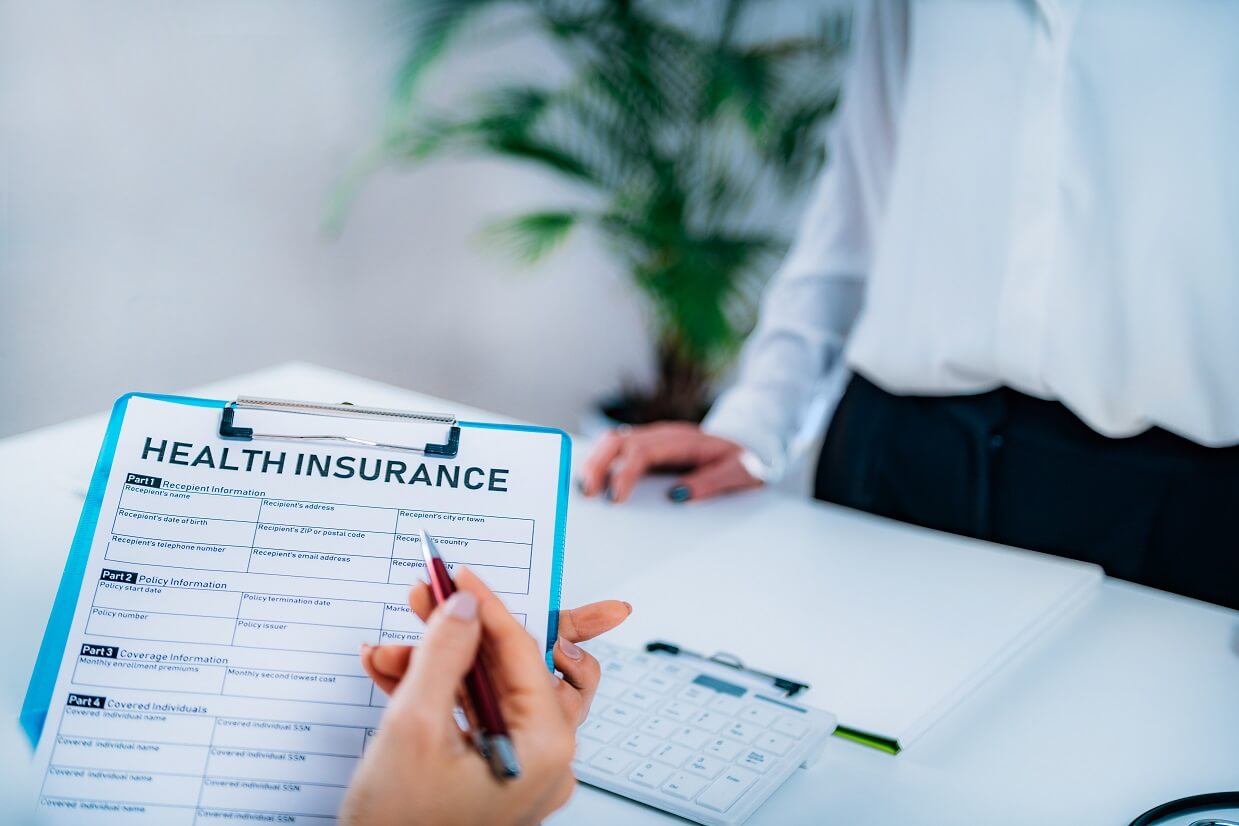 A person filling out a health insurance document