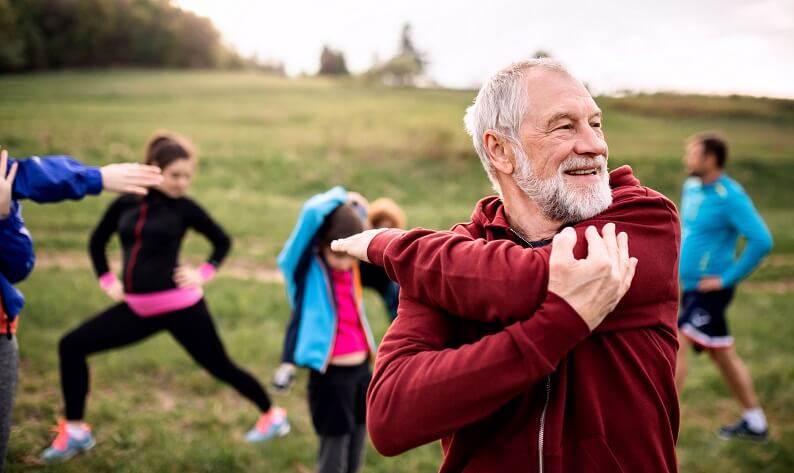 senior man with an exercise group outdoors