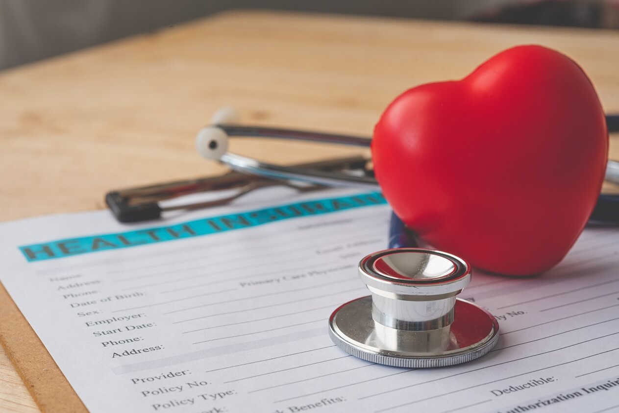 stethoscope placed on top of health insurance form