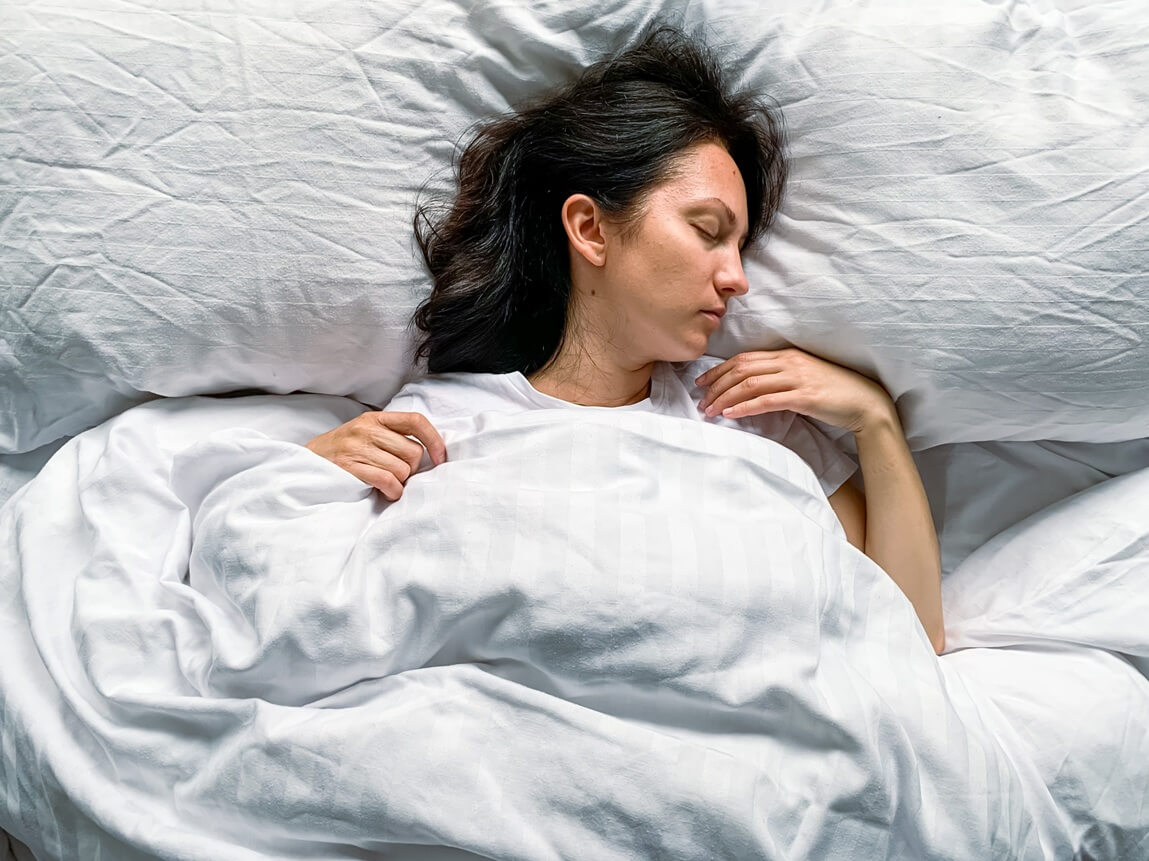 woman lay in a white bed sleeping