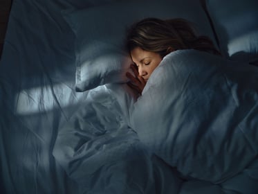 Relaxed woman sleeping in bed at night