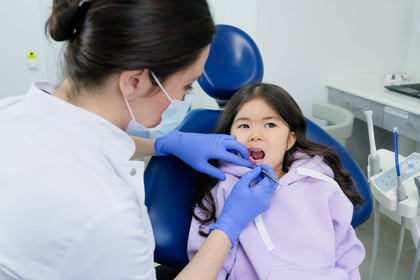 Woman in White Shirt Cleaning the Girl's Teeth