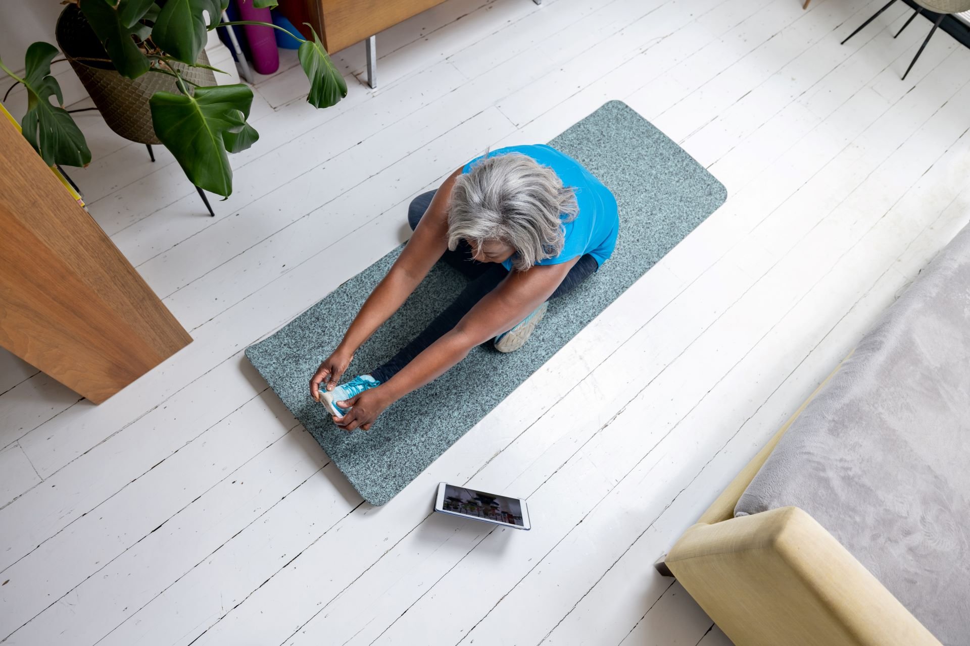 Woman over 50 exercising at home following an online class