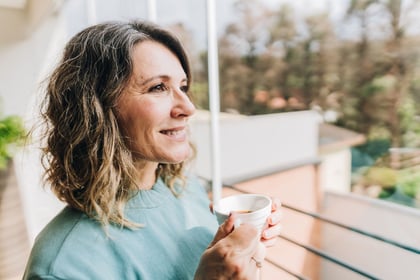 Woman over 50 looking away contemplating at home