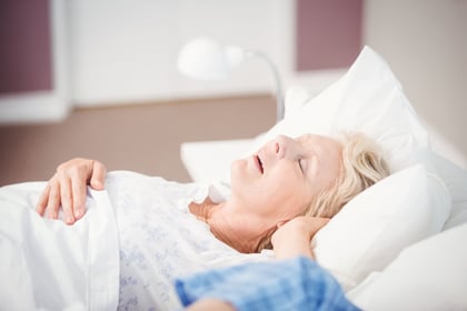 Woman snoring on bed