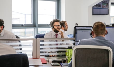 Man in the office on the phone to a customer.