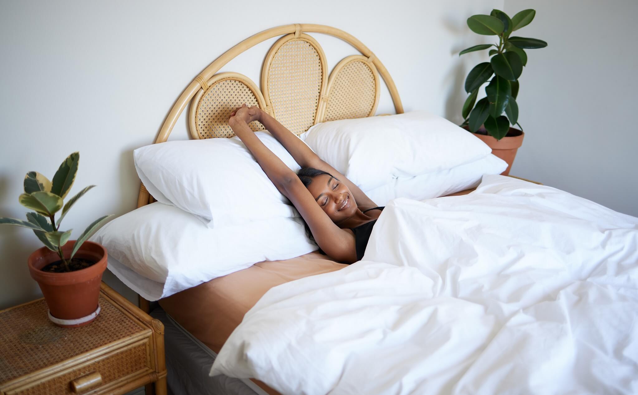 a woman in bed stretching 