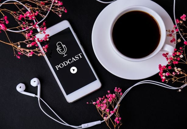 mobile-phone-podcast-with-headphones-on-workplace-2022-11-09-10-17-09-utc