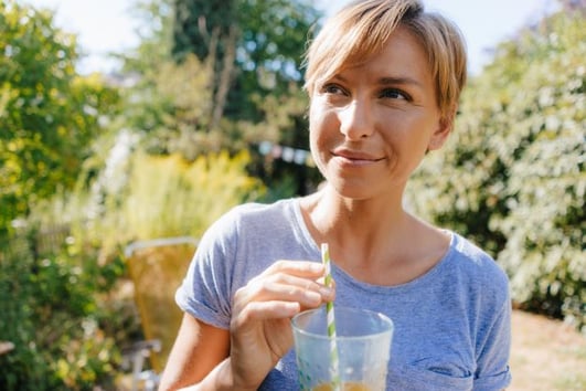 portrait-of-woman-drinking-a-soft-drink-in-garden-2022-private-health-insurance