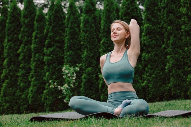 young-woman-practicing-yoga-on-the-grass-in-the-ga-2022-01-07-19-23-16-utc